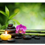 purple orchid, candle, with stones , bamboo on black mat